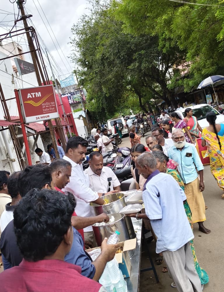 Trust volunteers ladling meals from steel pots for elderly people in Pattukkottai